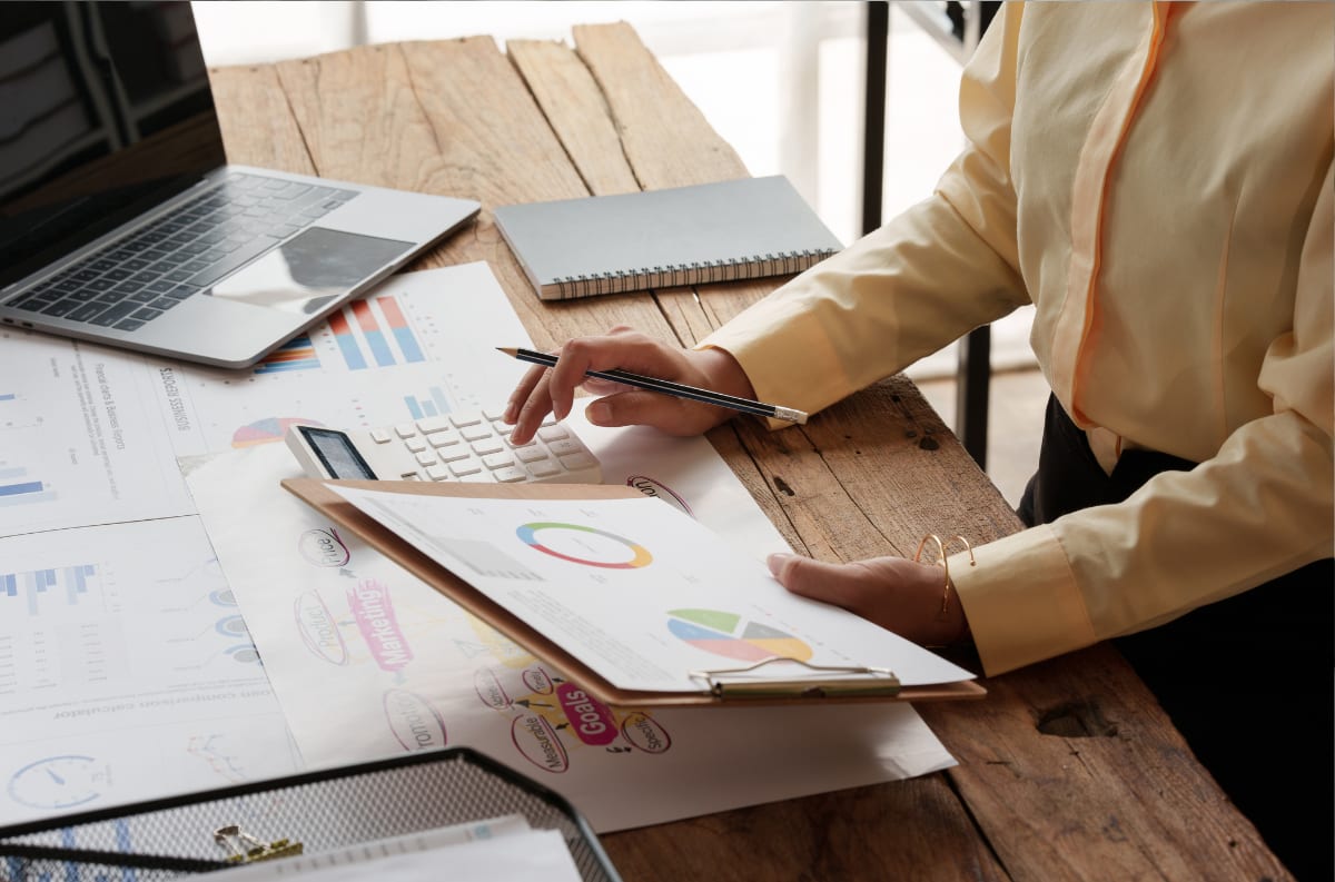Lender reviewing loan performance charts and calculations at a desk